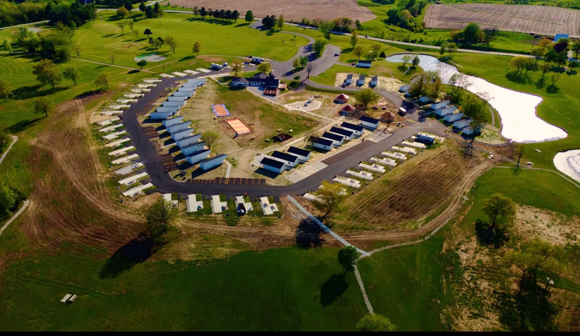 Aerial view of Haven Hills Campground & Resort with glamping yurts, park-model cabins, RV sites, pond and playground