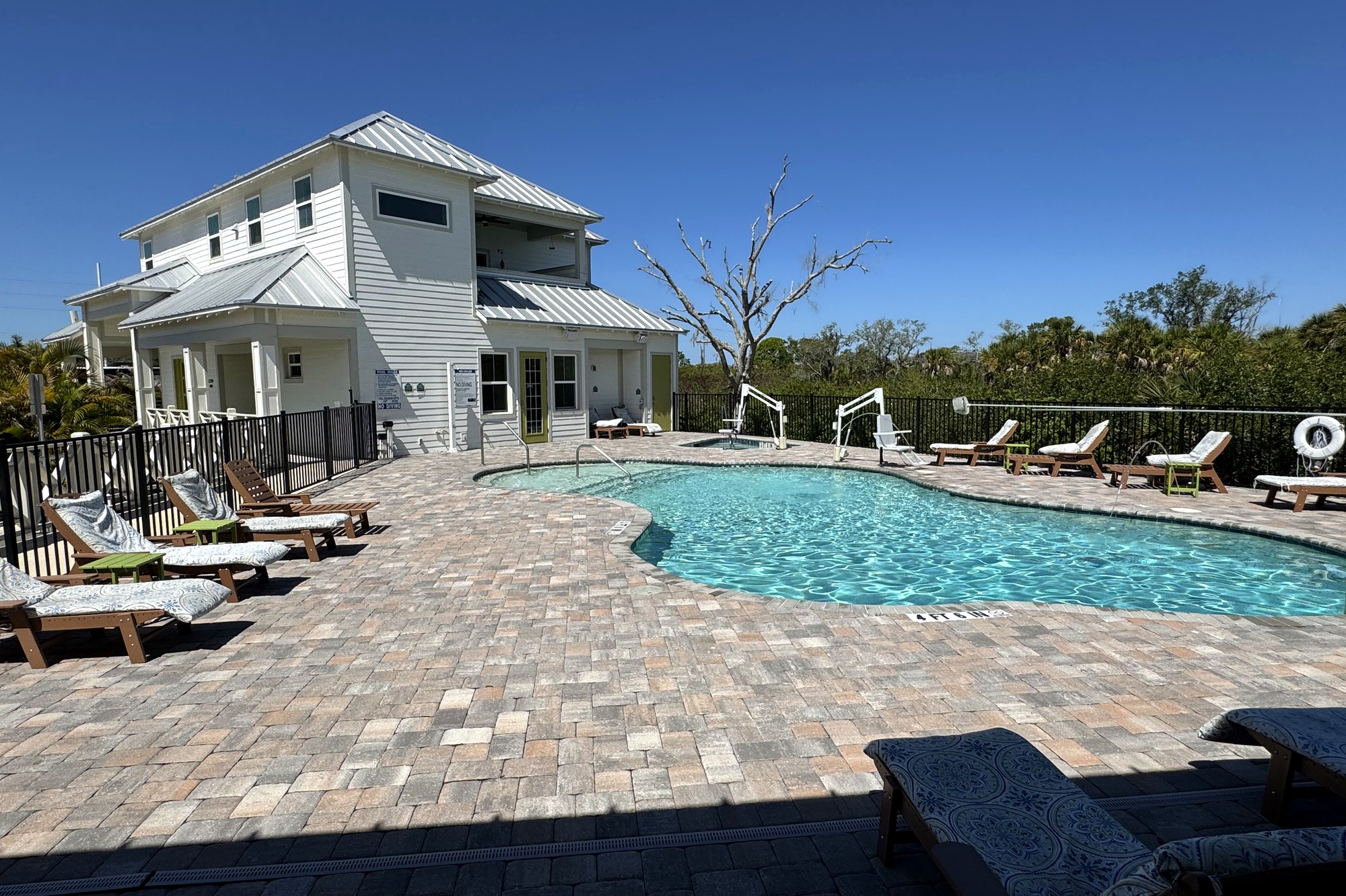 Two-story clubhouse with resort pool and paver deck at Keylime Bay RV Resort