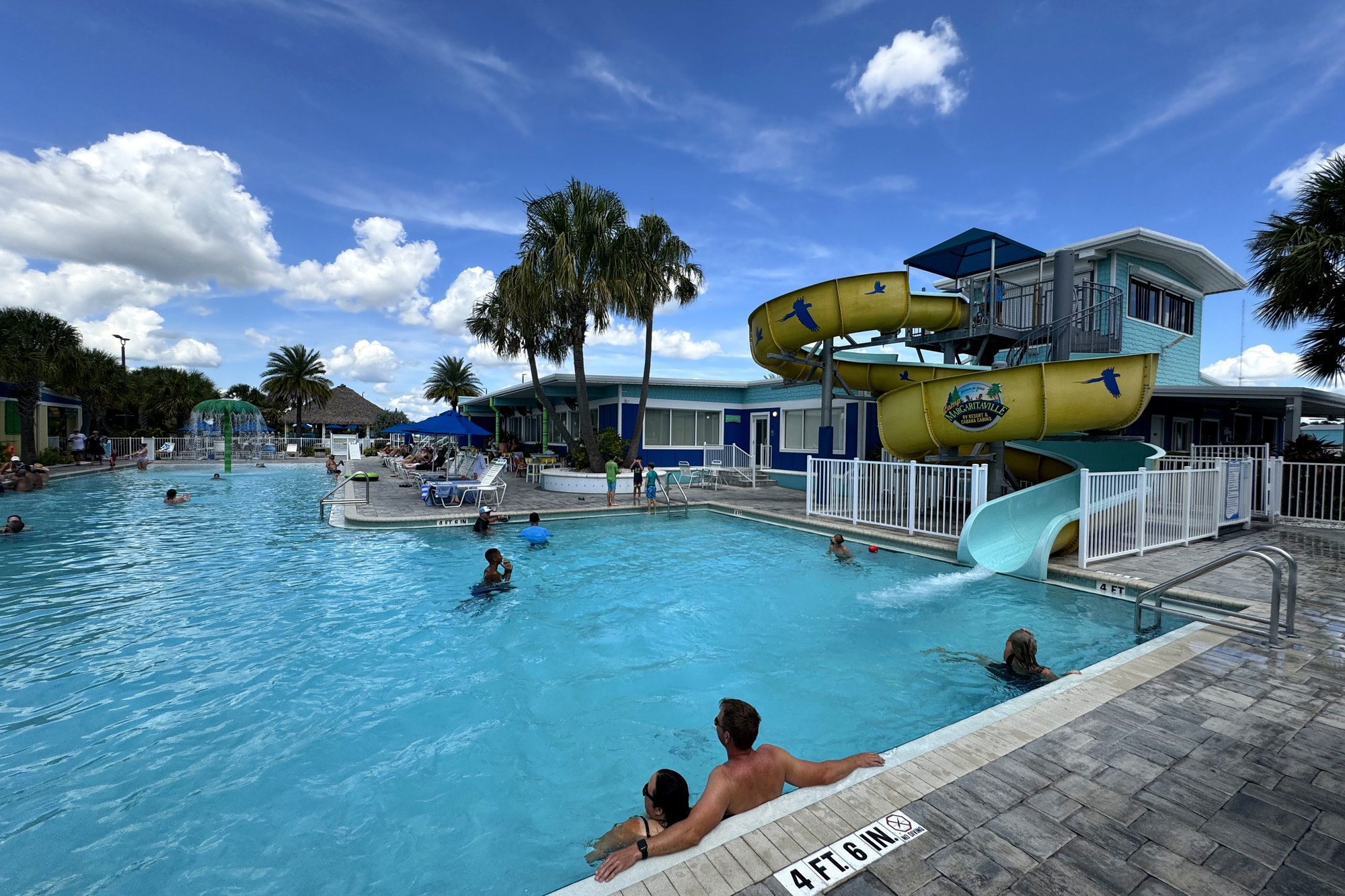 Resort pool with waterslides and shaded seating at Camp Margaritaville
