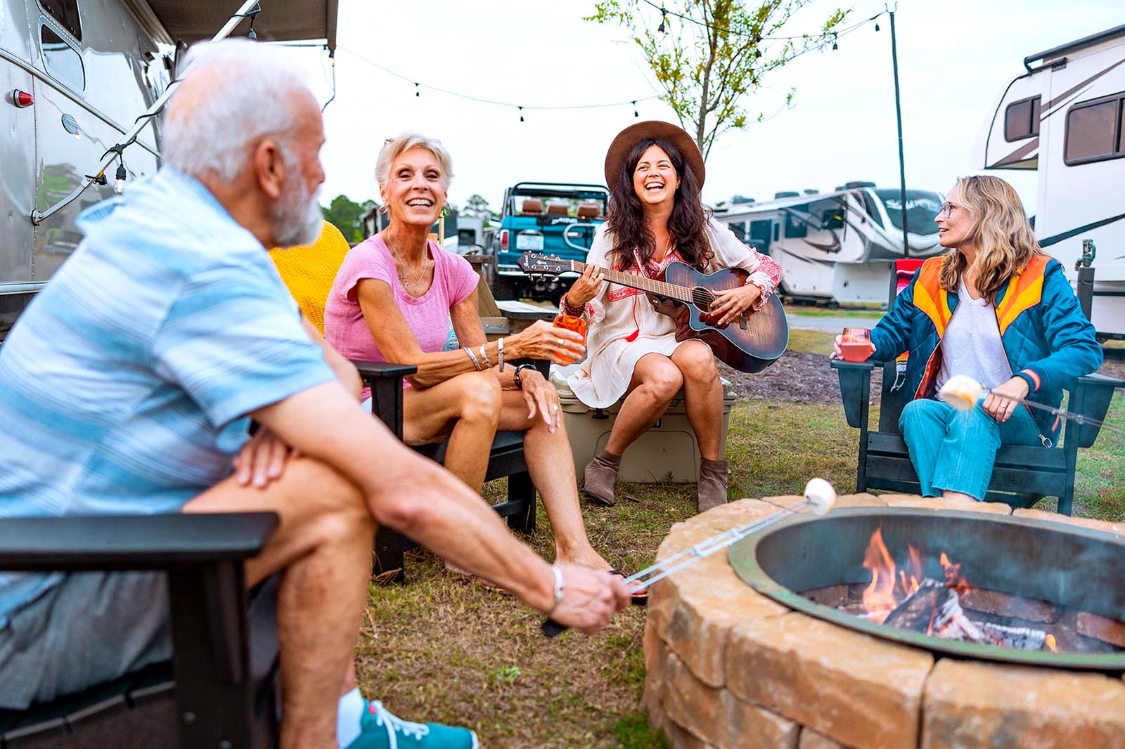 Guests gathered around a fire pit among RV sites at Oceans RV Resort